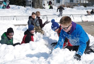Boys build snow forts in the snow.