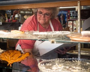 Connie reaches in display case.