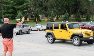 Man waves at cars in caravan